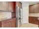 Close-up of a kitchen with stainless steel refrigerator and rich wood cabinets, offering modern convenience at 264 Wallrock Ct, Ocoee, FL 34761