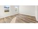 Bright bedroom featuring wood-look flooring, white walls and trim, and natural light from two windows at 265 Marion Oaks Mnr, Ocala, FL 34473