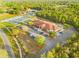 Aerial shot of a modern community center, surrounded by parking, tennis courts, and trees at 265 Marion Oaks Mnr, Ocala, FL 34473