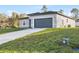 A modern single-story house shows off a new concrete driveway and gray garage door at 265 Marion Oaks Mnr, Ocala, FL 34473