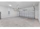 Spacious garage with a roll-up door, concrete walls and floor, and a ceiling light at 265 Marion Oaks Mnr, Ocala, FL 34473