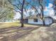 Landscaped backyard with mature trees and partial house view at 2810 Summerfield St, Deltona, FL 32738