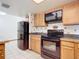 Kitchen with black appliances and wood cabinets at 2810 Summerfield St, Deltona, FL 32738