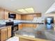 Kitchen with wood cabinets, black appliances, and a breakfast bar at 2810 Summerfield St, Deltona, FL 32738