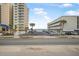 View of ocean from road, with building and parking in foreground at 3724 S Atlantic Ave # 20, Daytona Beach, FL 32118