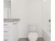 Modern bathroom with a white toilet, bathtub and tiled shower, and granite vanity at 4329 Switchgrass Ln, St Cloud, FL 34772