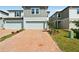 Charming townhomes with a brick driveway, attached garages, and a manicured lawn at 4329 Switchgrass Ln, St Cloud, FL 34772