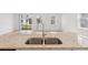 Close up of kitchen island featuring a stainless steel sink and tan speckled granite countertops at 4329 Switchgrass Ln, St Cloud, FL 34772