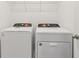 Modern laundry room with white washer and dryer and storage shelf above at 4329 Switchgrass Ln, St Cloud, FL 34772