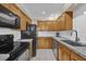 Kitchen with wood cabinets, black appliances, and granite countertops at 526 Orange Dr # 37, Altamonte Springs, FL 32701