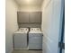 A well-organized laundry room features gray cabinets and a new washer and dryer at 5374 Lake Virginia St, Winter Garden, FL 34787