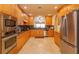 Modern kitchen with wood cabinets, granite counters, and stainless steel appliances at 8755 The Esplanade # 103, Orlando, FL 32836