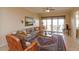 Open living area with hardwood floors, sectional sofa, and access to balcony at 8755 The Esplanade # 103, Orlando, FL 32836