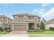Two-story home with neutral siding, brick paver driveway, and landscaping at 936 Jetway Street, Orange City, FL 32763