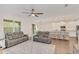 Spacious living room with hardwood floors, gray couches, and a view into the kitchen at 936 Jetway Street, Orange City, FL 32763