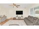 Living room with hardwood floors, gray sectional sofa, and a large flat-screen TV at 936 Jetway Street, Orange City, FL 32763