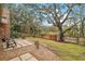 Spacious backyard with large oak tree and wooden fence at 9908 Fairway Cir, Leesburg, FL 34788