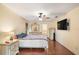 Spacious bedroom with hardwood floors, large TV, and ensuite bathroom access at 9908 Fairway Cir, Leesburg, FL 34788