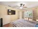 Bedroom with hardwood floors, large window, and access to a sunroom at 9908 Fairway Cir, Leesburg, FL 34788