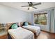 Bedroom with two twin beds, ceiling fan, and large window at 9908 Fairway Cir, Leesburg, FL 34788