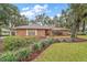 Brick home with mature trees and well-manicured lawn at 9908 Fairway Cir, Leesburg, FL 34788