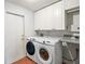 Bright laundry room with washer, dryer, cabinets, and countertop at 9908 Fairway Cir, Leesburg, FL 34788