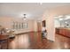 Living room with hardwood floors, vaulted ceiling, and views to kitchen and entry at 9908 Fairway Cir, Leesburg, FL 34788