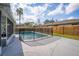 Backyard view of the fenced-in swimming pool surrounded by a concrete deck and well-manicured lawn at 102 Aberdeen Dr, Fern Park, FL 32730