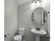 Powder room with pedestal sink and round mirror at 1267 Marley Ln, Winter Springs, FL 32708