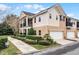 Tan townhome exterior with a walkway, landscaping, and attached garage at 1267 Marley Ln, Winter Springs, FL 32708