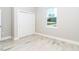 Spacious bedroom with white sliding doors and wood-look tile floors at 12707 Sw 78Th Pl, Dunnellon, FL 34432