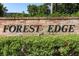 A welcoming brick sign at Forest Edge, framed by lush green hedges and mature trees at 1369 Black Willow Trl, Altamonte Springs, FL 32714