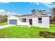 Newly constructed home with a gray garage door and lush lawn at 14 Fisher Loop Pass, Ocklawaha, FL 32179