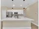 Modern kitchen with white cabinets, quartz countertops and island at 14 Fisher Loop Pass, Ocklawaha, FL 32179