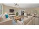 Open living area with beige sofas, a coffee table, and a view into the kitchen at 14 Fisher Loop Pass, Ocklawaha, FL 32179