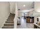 View from entryway showing a staircase, tiled floors, and a view into the living room and kitchen at 1498 Moon Valley Dr, Davenport, FL 33896