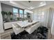 Modern dining room with large table, chandelier, and gray walls at 16750 Toccoa Row, Winter Garden, FL 34787