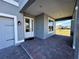 Covered front porch with brick flooring and white door at 16750 Toccoa Row, Winter Garden, FL 34787