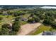 Scenic aerial view of the property, featuring lush fields, mature trees, and neighboring farmland at 17901 Coralwood Ln, Groveland, FL 34736