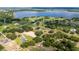 Picturesque aerial view of the estate showcasing a tranquil lake and a luxurious home with a private pool at 17901 Coralwood Ln, Groveland, FL 34736