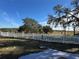 View of backyard with white fence and open field at 17901 Coralwood Ln, Groveland, FL 34736