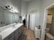 Main bathroom with double vanity, updated fixtures, and a large mirror at 17901 Coralwood Ln, Groveland, FL 34736
