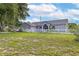 Single story home exterior showcasing a large grassy lot at 17901 Coralwood Ln, Groveland, FL 34736