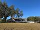 Ranch-style home with white picket fence and expansive yard at 17901 Coralwood Ln, Groveland, FL 34736