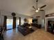 Bright living room featuring a large TV and comfortable leather sofas at 17901 Coralwood Ln, Groveland, FL 34736