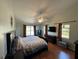 Main bedroom with wood floors, large window, and a ceiling fan at 17901 Coralwood Ln, Groveland, FL 34736