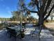Relaxing patio furniture under a large oak tree at 17901 Coralwood Ln, Groveland, FL 34736