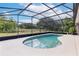 Screened in pool with a view of the property's surrounding land at 17901 Coralwood Ln, Groveland, FL 34736