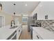 Modern kitchen with white cabinets, quartz countertops, and stainless steel appliances at 18 Malauka Pass Ter, Ocklawaha, FL 32179