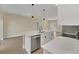 Modern kitchen island with white quartz countertop, stainless steel dishwasher, and black faucet at 18 Malauka Pass Ter, Ocklawaha, FL 32179